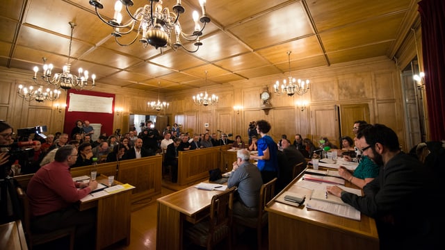 Blick in einen Saal mit U-förmig angelegten Pulten. Blick in einen Saal mit U-förmig angelegten Pulten.