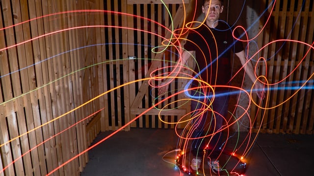 Bunte Linien im Raum laufen auf einen Reif zu, der am Boden liegt. Bunte Linien im Raum laufen auf einen Reif zu, der am Boden liegt.