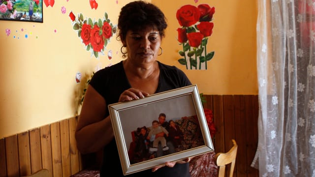 Erzsebet Csorba mit einem Familienfoto in ihrem Wohnzimmer in Tatarszentgyorgy.