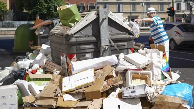 Ein Mann wirft eine Tüte auf einen Container, rundherum steht schon viel Abfall. Ein Mann wirft eine Tüte auf einen Container, rundherum steht schon viel Abfall.