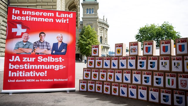 Kartonsschachachteln auf denen Kantonswappen aufgeklebt sind, Abstimmungsplakat. Kartonsschachachteln auf denen Kantonswappen aufgeklebt sind, Abstimmungsplakat.