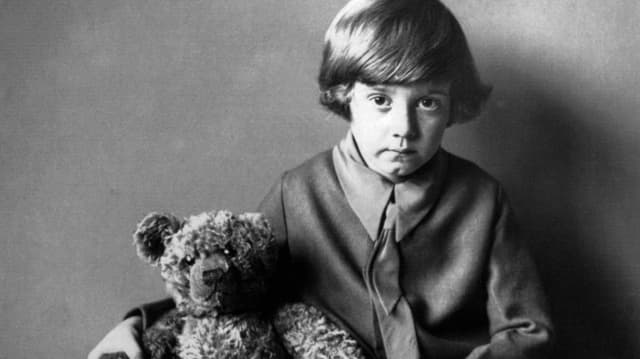 Ein junge schaut in die Kamera. Im Arm hält er einen Teddybären. Ein junge schaut in die Kamera. Im Arm hält er einen Teddybären.