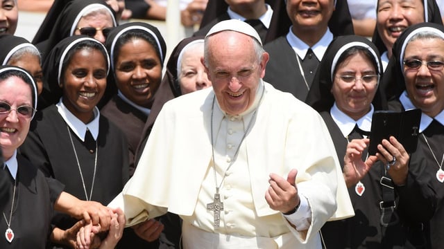 Papst, umringt von Nonnen.