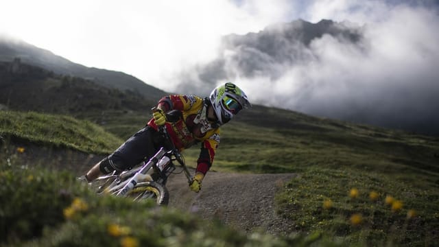 Ein Mountainbiker fährt in der Lenzerheide einen Trail hinunter Ein Mountainbiker fährt in der Lenzerheide einen Trail hinunter