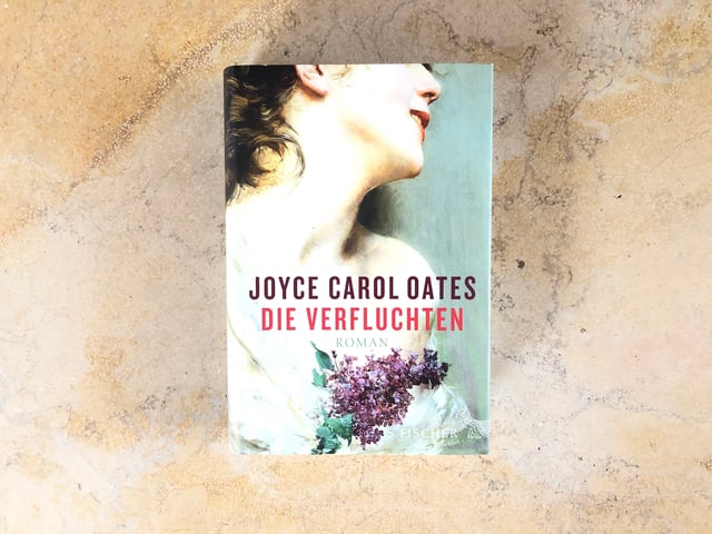 Der Roman «Die Verfluchten» von Joyce Carol Oates liegt auf einer Marmorplatte Der Roman «Die Verfluchten» von Joyce Carol Oates liegt auf einer Marmorplatte