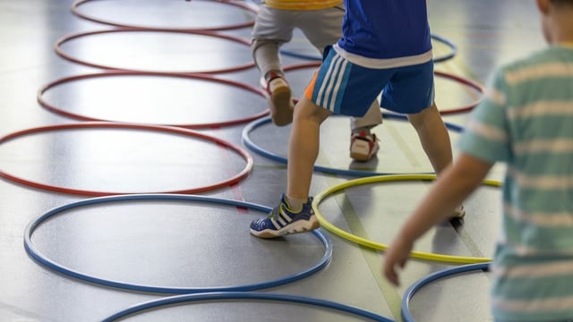 Turnende in einer Sporthalle Turnende in einer Sporthalle