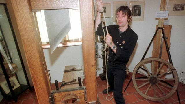 Der Besitzer des Henkersmuseums demonstriert eine Guillotine Der Besitzer des Henkersmuseums demonstriert eine Guillotine