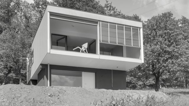 ein schwarz-weiss Foto von einem quadratischen Haus am Hang ein schwarz-weiss Foto von einem quadratischen Haus am Hang