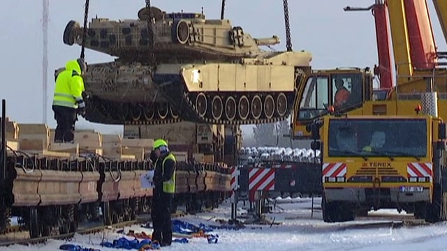 Ein Panzer wird mit einem mobilen Kranwagen von einem Eisenbahnwagen abgeladen. Ein Panzer wird mit einem mobilen Kranwagen von einem Eisenbahnwagen abgeladen.