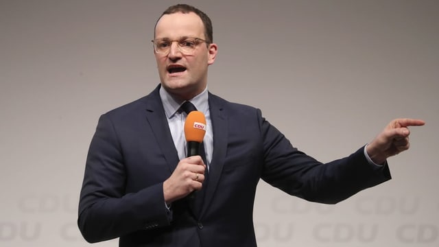 Jens Spahn mit Mikrofon in der Hand. Jens Spahn mit Mikrofon in der Hand.