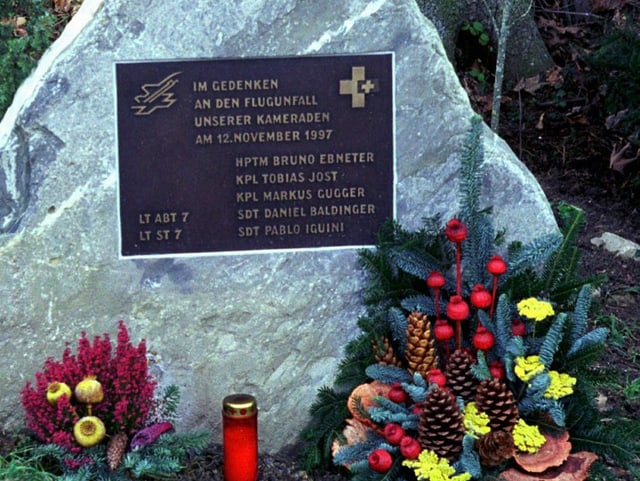 Gedenktafel am Absturzort bei Boltigen, Blumen und eine Grabkerze davor.