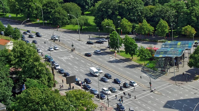 Eine mehrspurige Kreuzung, umgeben von Bäumen und Grünflächen in der Stadt Hamburg. Eine mehrspurige Kreuzung, umgeben von Bäumen und Grünflächen in der Stadt Hamburg.