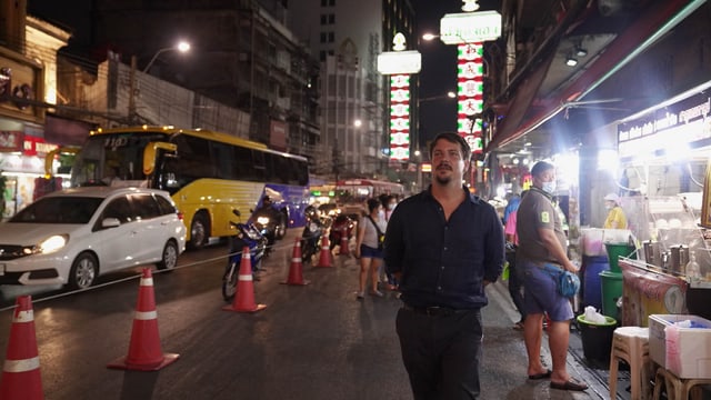 Mann auf einer belebten Food-Strasse in Bankok Mann auf einer belebten Food-Strasse in Bankok