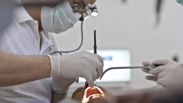Purtret d'in dentist ch'è gist vid guardar en la bucca ad in pazient. Purtret d'in dentist ch'è gist vid guardar en la bucca ad in pazient.