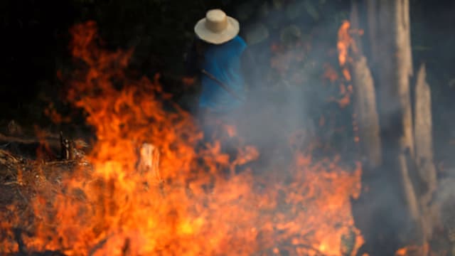 Ein Mann steht hinter einem Feuer. Ein Mann steht hinter einem Feuer.