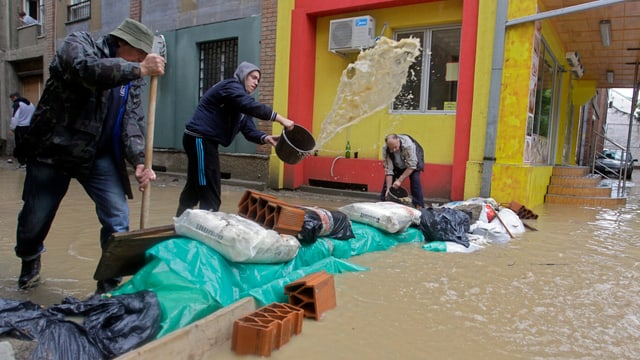 Mit Eimern versuchen Einwohner in Obrenovac das Wasser abzuschöpfen. Mit Eimern versuchen Einwohner in Obrenovac das Wasser abzuschöpfen.