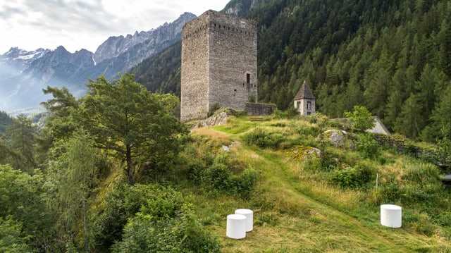 Ein Turm einer Burgruine, davor am Hang drei glänzende Heuballen. Ein Turm einer Burgruine, davor am Hang drei glänzende Heuballen.