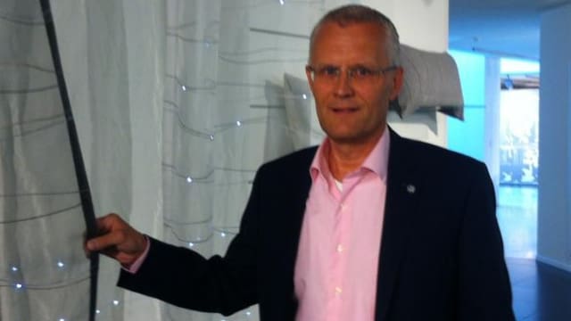 Anton Minder hält einen Vorhang. Anton Minder hält einen Vorhang.