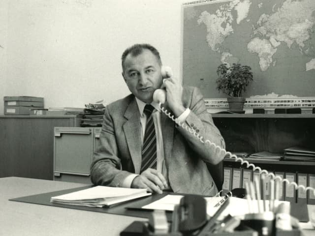 Schwarz-Weiss-Fotografie mit dem Reiseberater, der während eines Telefongesprächs hinter seinem Schreibtisch sitzt. Schwarz-Weiss-Fotografie mit dem Reiseberater, der während eines Telefongesprächs hinter seinem Schreibtisch sitzt.