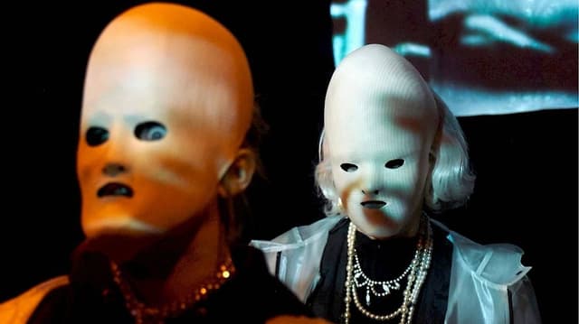 Zwei Menschen mit eierförmigen Masken. Zwei Menschen mit eierförmigen Masken.