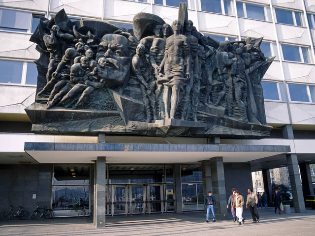 Das Portalrelief zeigt ein Bild von Marx, umgeben von Arbeitern. Das Portalrelief zeigt ein Bild von Marx, umgeben von Arbeitern.
