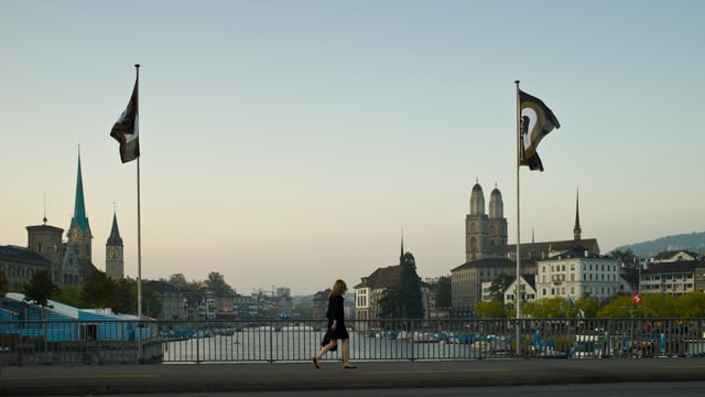Eine Frau läuft über die Brücke, die Festivalfahnen wehen. Eine Frau läuft über die Brücke, die Festivalfahnen wehen.