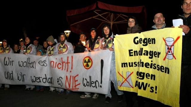 Gruppe mit Plakaten mit den Aufschriften "Wir wollen es nicht! Und wir werden es nie wollen!" sowie "Gegen Endlager muss heissen gegen AKWs" Gruppe mit Plakaten mit den Aufschriften "Wir wollen es nicht! Und wir werden es nie wollen!" sowie "Gegen Endlager muss heissen gegen AKWs"