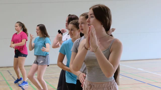 Tanzende jugendliche Mädchen, die in einer Reihe in der Turnhalle stehen. Tanzende jugendliche Mädchen, die in einer Reihe in der Turnhalle stehen.