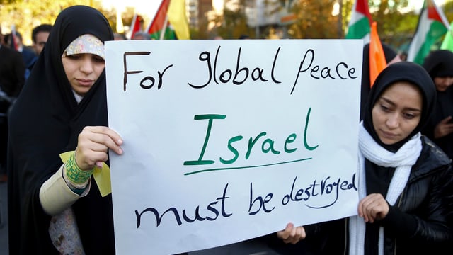 Zwei Frauen halten ein Plakat mit der Aufschrift «For global peace, Israel must be destroyed». Zwei Frauen halten ein Plakat mit der Aufschrift «For global peace, Israel must be destroyed».