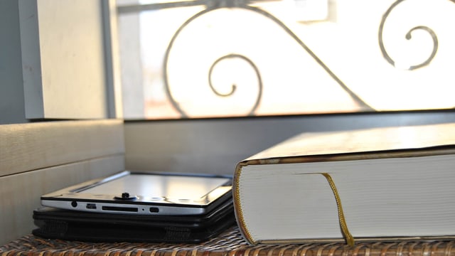 Das Bild zeigt ein dickes Buch und einen E-Reader Das Bild zeigt ein dickes Buch und einen E-Reader