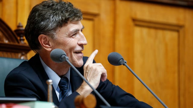 Mann spricht im Parlament auf dem Sitz des Nationalratspräsidenten. Mann spricht im Parlament auf dem Sitz des Nationalratspräsidenten.