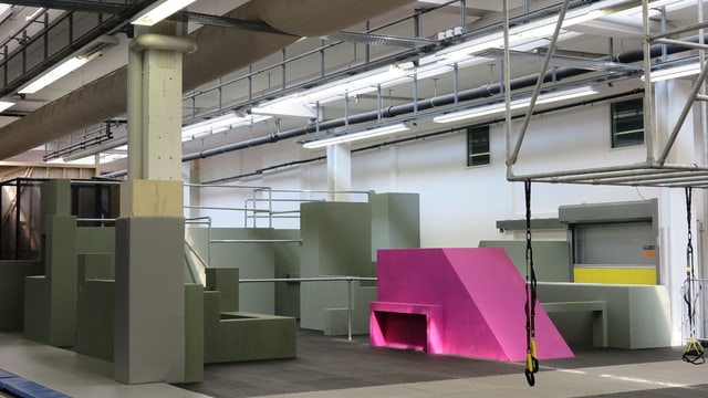 Eine Fabrikhalle mit Betonelementen, eines davon pink angemalt. Eine Fabrikhalle mit Betonelementen, eines davon pink angemalt.