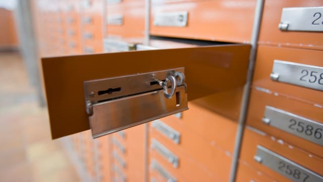 Ein offenes braunfarbenes Schliessfach mit Schlüssel. Ein offenes braunfarbenes Schliessfach mit Schlüssel.