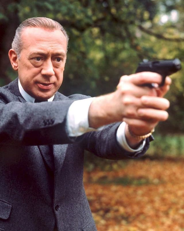 Horst Tappert zielt als Inspektor Stephan Derrick Richtung Kamera. Horst Tappert zielt als Inspektor Stephan Derrick Richtung Kamera.