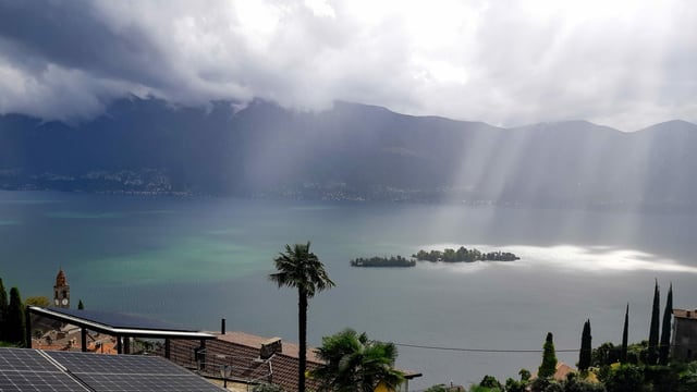 Sonnenstrahlen treffen genau die Brissago-Inseln sonst ist es noch grau. Sonnenstrahlen treffen genau die Brissago-Inseln sonst ist es noch grau.