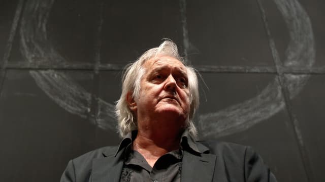 Mankell vor einer schwarzen Wand mit einem weissen Kreis. Mankell vor einer schwarzen Wand mit einem weissen Kreis.