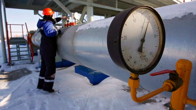 Gasleitung, mit Messinstrument. Arbeiter im Hintergrund. Gasleitung, mit Messinstrument. Arbeiter im Hintergrund.