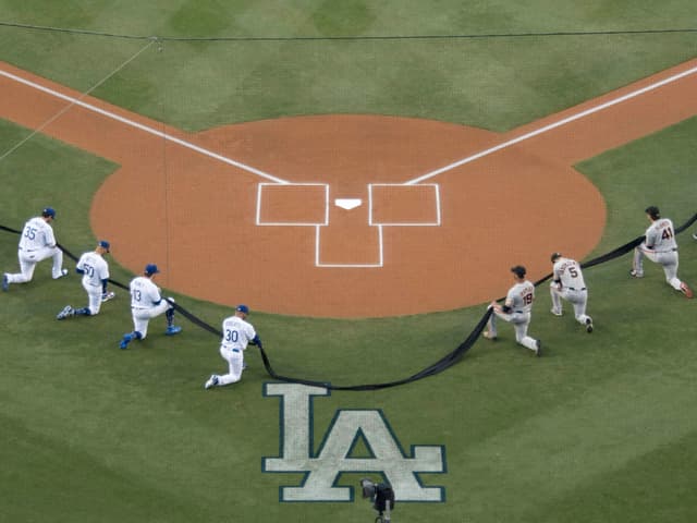Die Spieler der Los Angeles Dodgers und der San Francisco Giants gehen auf ein Knie. Die Spieler der Los Angeles Dodgers und der San Francisco Giants gehen auf ein Knie.
