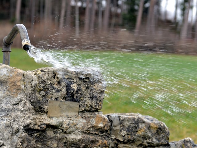 Kräftiger Wind verbläst das Wasser eines Brunnens Kräftiger Wind verbläst das Wasser eines Brunnens