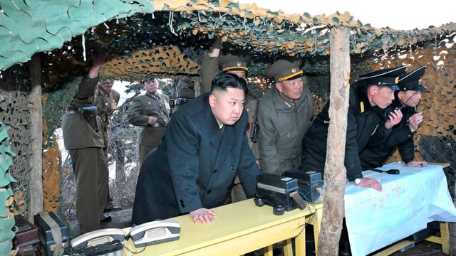Kim Jong Un mit Militärs in einem Unterstand unter einem Tarnnetz. Kim Jong Un mit Militärs in einem Unterstand unter einem Tarnnetz.