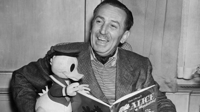 Ein Mann mit Donald und einem Buch in der Hand. Ein Mann mit Donald und einem Buch in der Hand.