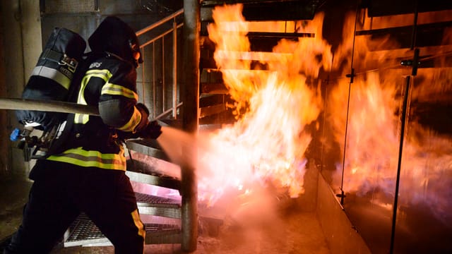 Feuerwehrmann beim Löschen von Flammen Feuerwehrmann beim Löschen von Flammen