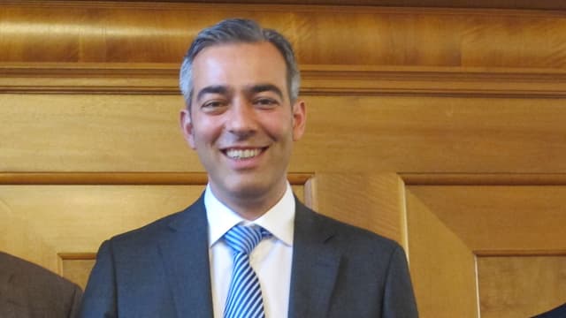 Mann mit blauer Krawatte und Anzug und grauen Haaren lächelt Mann mit blauer Krawatte und Anzug und grauen Haaren lächelt