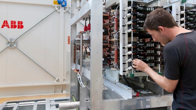 Ein Mann arbeitet an einer Elektro-Installation. Ein Mann arbeitet an einer Elektro-Installation.