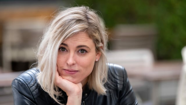 eine junge blonde Frau schaut etwas nachdenklich in die Kamera eine junge blonde Frau schaut etwas nachdenklich in die Kamera