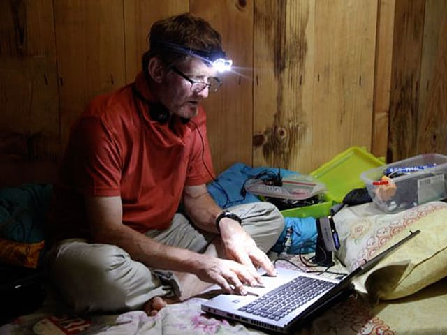 Tommy Dätwyler mit Stirnlampe am Computer. Tommy Dätwyler mit Stirnlampe am Computer.