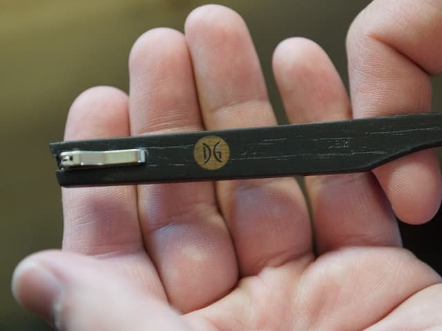 Ein Brillenbügel in einer Hand. Ein Brillenbügel in einer Hand.
