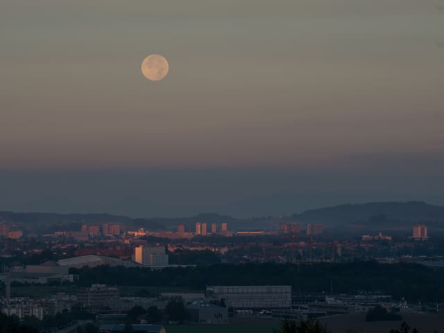 Morgendämmerung mit Vollmond über der Stadt Bern.