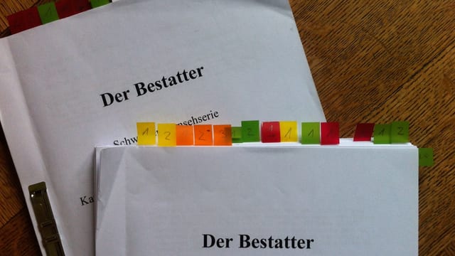 Zwei Drehbücher mit farbigen Post-Its, die gewisse Seiten mit farben markieren. Zwei Drehbücher mit farbigen Post-Its, die gewisse Seiten mit farben markieren.