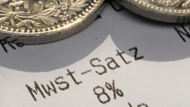 Kassenzettel mit der Angabe über den MwSt.-Satz und Münzen. Kassenzettel mit der Angabe über den MwSt.-Satz und Münzen.